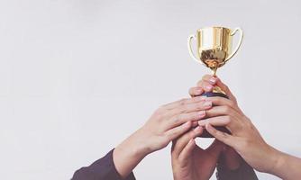 hand-of-team-business-holding-a-golden-trophy-concept-teamwork-free-photo