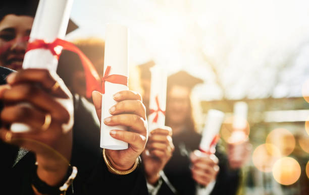 Cropped shot of a group of students holding their diplomas on graduation day